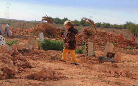 Une petite fille apporte une rose rouge au cimetière pour rendre hommage à son père décédé (c) Life for Syria