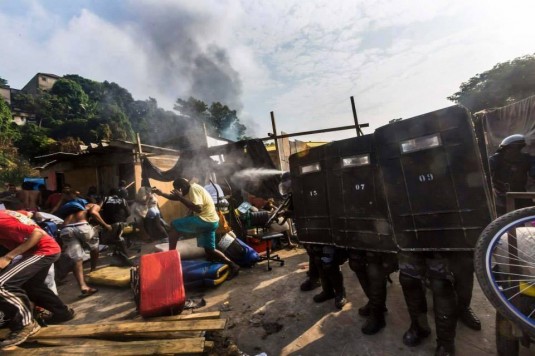 Evacuation d'une favela de Rio par les unités de police pacificatrices. Est-ce que ça vaut un dribble du multi-millionaire Ronaldo? © Abdeslam Kelai